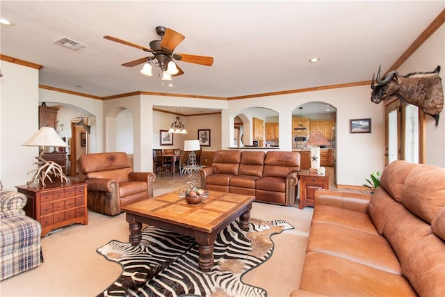 carpeted living room with ceiling fan with notable chandelier and ornamental molding