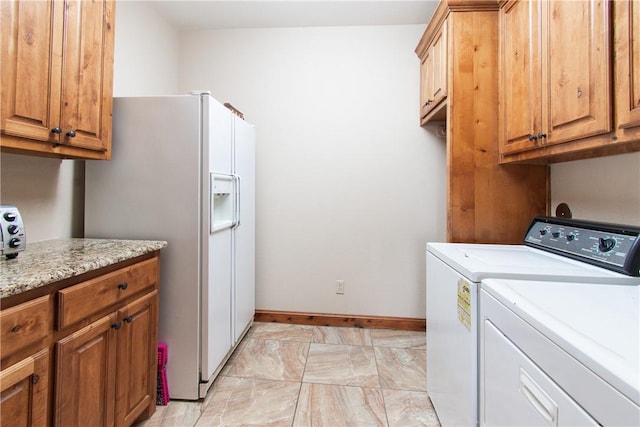 washroom featuring cabinets and washer and clothes dryer