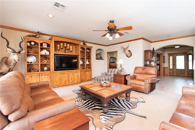 tiled living room with ceiling fan and ornamental molding