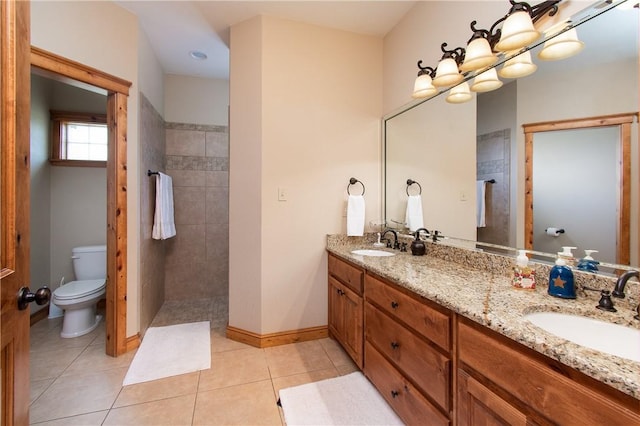 bathroom with tile patterned floors, vanity, a tile shower, and toilet