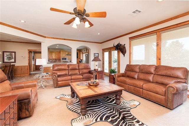 living room with crown molding, french doors, ceiling fan, and light carpet