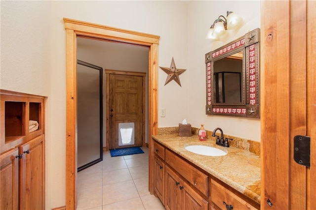 bathroom with tile patterned flooring, vanity, and walk in shower