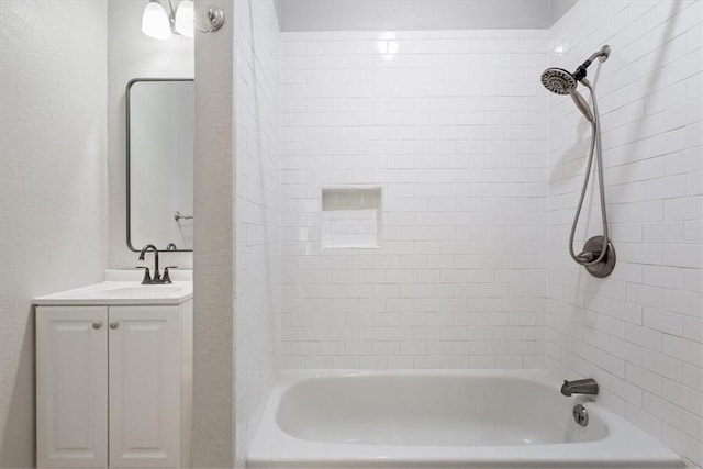 bathroom with tiled shower / bath combo and vanity