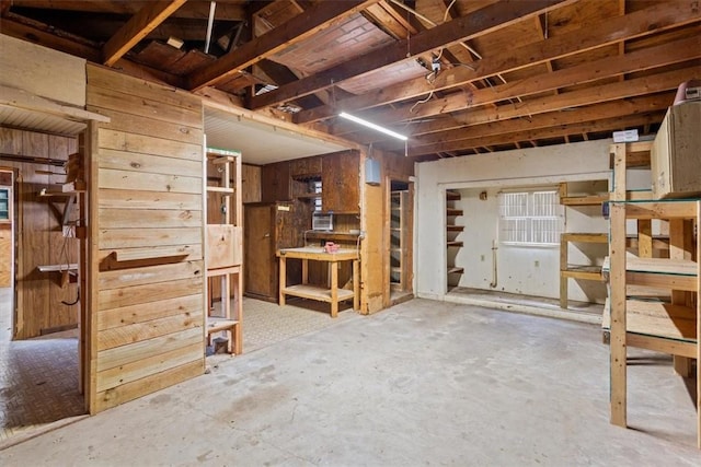 basement featuring a workshop area and wooden walls