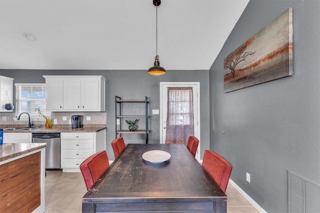 tiled dining area with lofted ceiling and sink