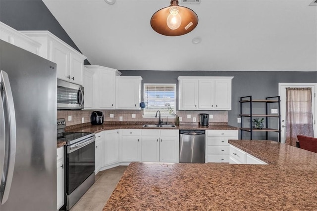 kitchen with stainless steel appliances, white cabinetry, lofted ceiling, and sink