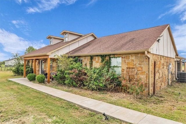 view of front of property featuring a front yard and central AC