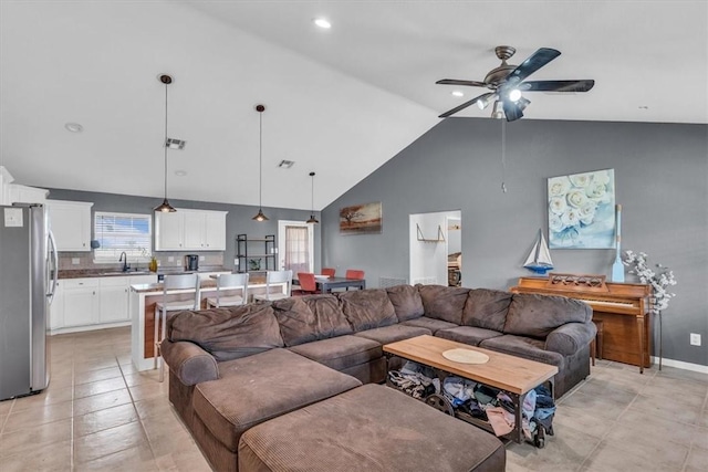 living room with light tile patterned floors, high vaulted ceiling, ceiling fan, and sink