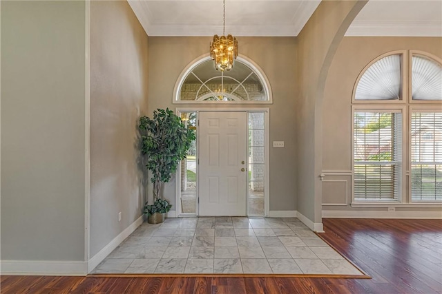 entrance foyer with an inviting chandelier, light hardwood / wood-style flooring, and ornamental molding