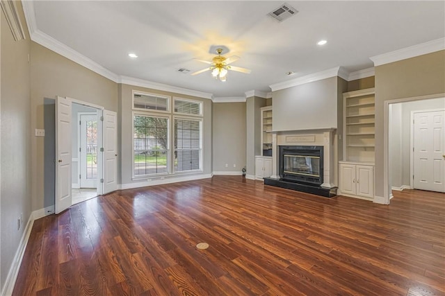 unfurnished living room featuring built in shelves, ceiling fan, dark hardwood / wood-style flooring, and crown molding