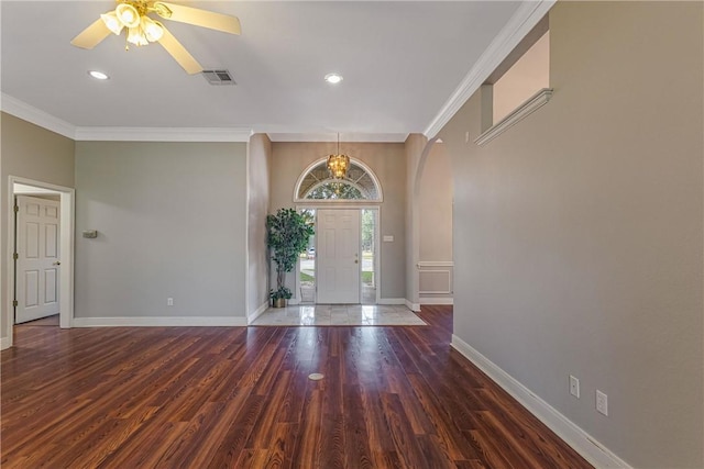 foyer with ceiling fan with notable chandelier, ornamental molding, and dark wood-type flooring