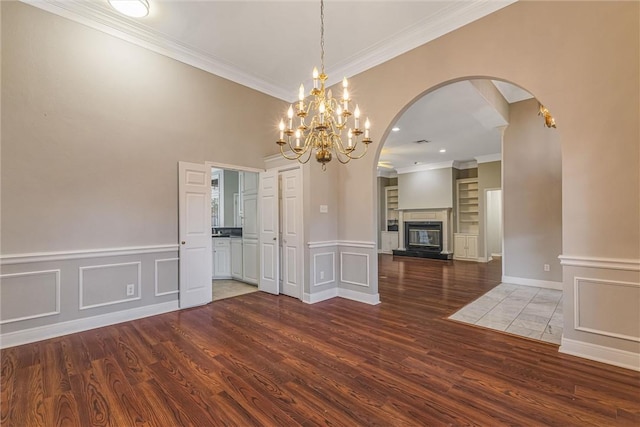 unfurnished dining area with ornamental molding, dark hardwood / wood-style floors, and an inviting chandelier