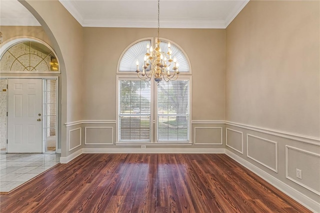 interior space with dark hardwood / wood-style flooring, crown molding, and a notable chandelier