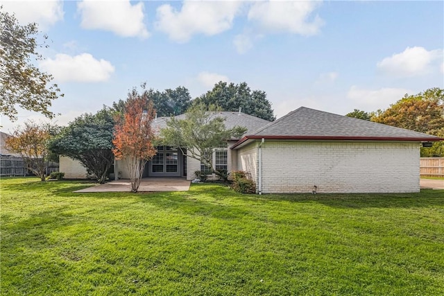 back of property with a lawn and a patio