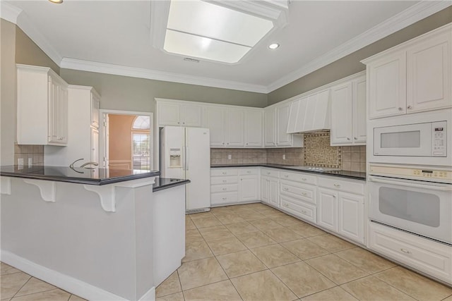 kitchen with kitchen peninsula, white cabinetry, white appliances, and ornamental molding