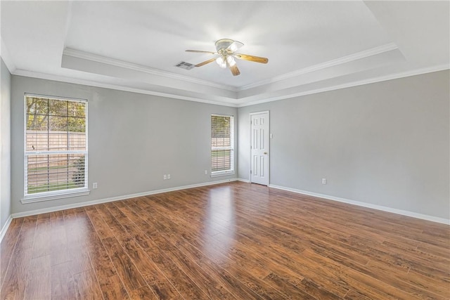 unfurnished room with dark hardwood / wood-style flooring, ceiling fan, a raised ceiling, and ornamental molding