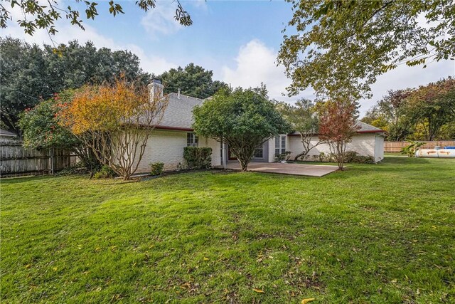 rear view of house featuring a patio area and a yard