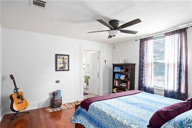 bedroom with ceiling fan, hardwood / wood-style floors, ensuite bathroom, and a textured ceiling