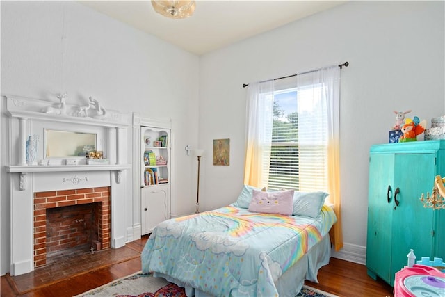 bedroom with a fireplace and wood-type flooring