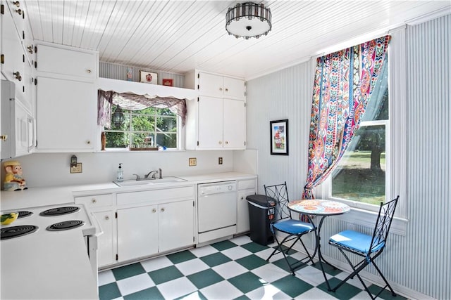 kitchen featuring plenty of natural light, white cabinetry, sink, and white appliances