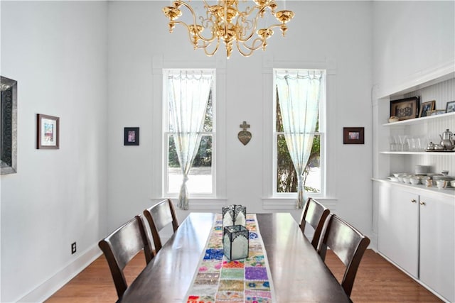 dining room with wood-type flooring and an inviting chandelier