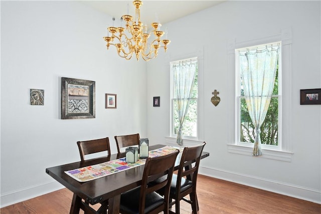 dining space with hardwood / wood-style flooring and a chandelier