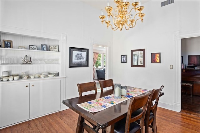 dining area featuring a chandelier, hardwood / wood-style floors, and a high ceiling