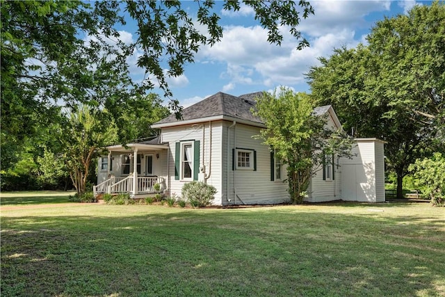 rear view of property with a porch and a yard