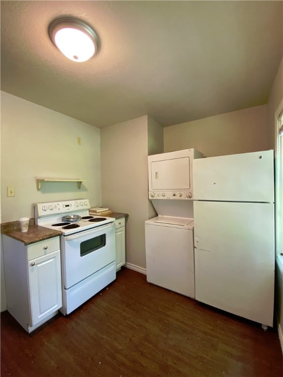 kitchen featuring dark hardwood / wood-style flooring, white appliances, white cabinetry, and stacked washer / drying machine