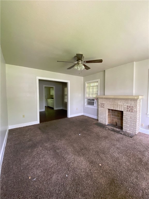 unfurnished living room featuring dark colored carpet, a brick fireplace, cooling unit, and ceiling fan