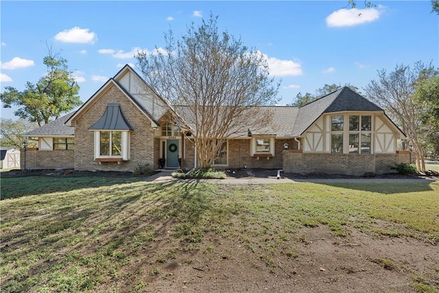 english style home featuring a front lawn