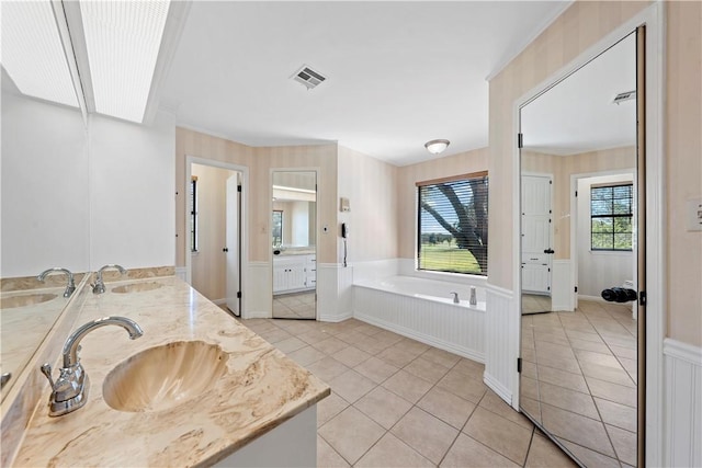 bathroom with a bathing tub, tile patterned flooring, and vanity