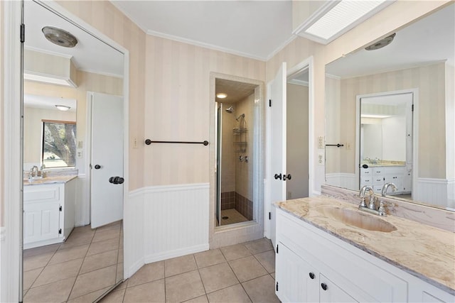 bathroom with vanity, tile patterned floors, a shower with door, and crown molding