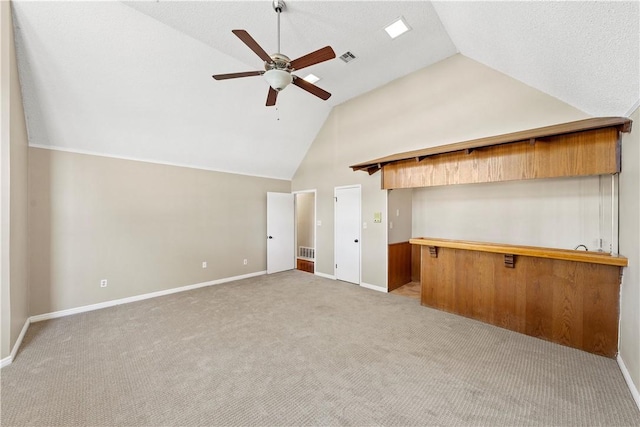 unfurnished living room with ceiling fan, light colored carpet, and high vaulted ceiling