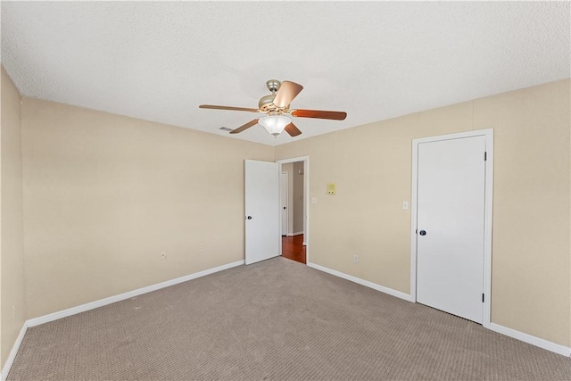 carpeted empty room with ceiling fan and a textured ceiling