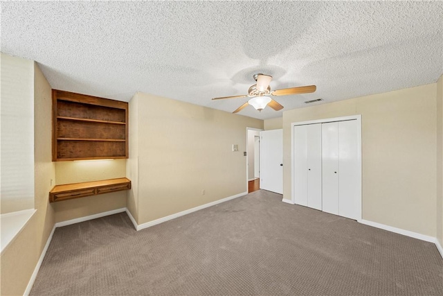 unfurnished bedroom featuring a textured ceiling, carpet floors, a closet, and ceiling fan