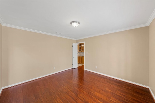 empty room featuring hardwood / wood-style floors and ornamental molding