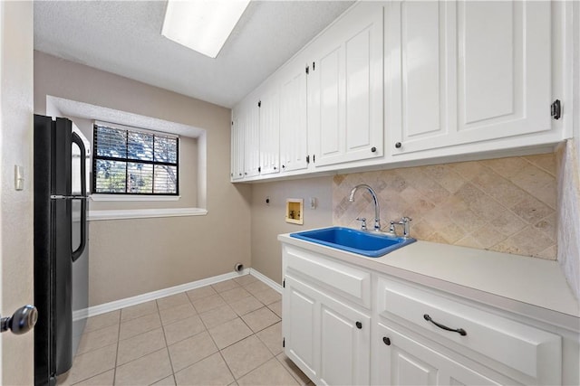 laundry room featuring sink, cabinets, hookup for an electric dryer, hookup for a washing machine, and light tile patterned flooring