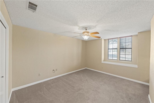 empty room featuring light carpet and a textured ceiling