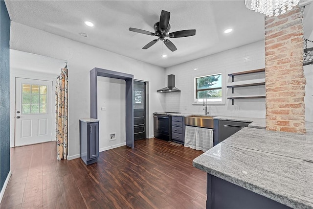 kitchen with light stone counters, dark wood-type flooring, wall chimney range hood, sink, and electric stove