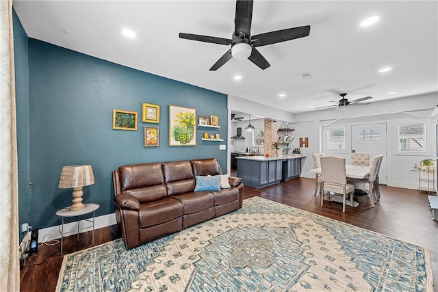 living room with dark hardwood / wood-style flooring and ceiling fan