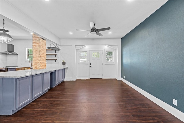 interior space featuring wall chimney range hood, a wealth of natural light, sink, and dark hardwood / wood-style floors