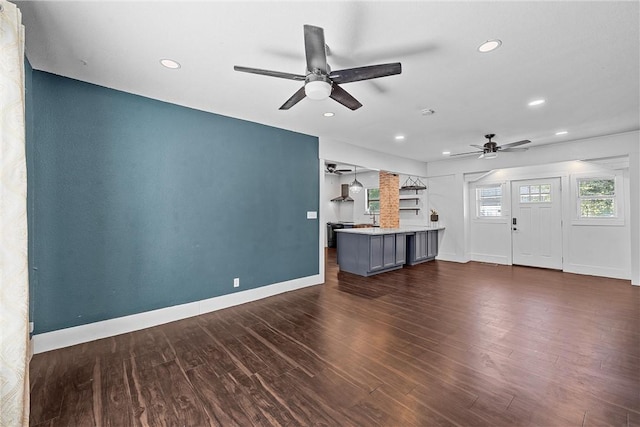 unfurnished living room featuring dark hardwood / wood-style floors and ceiling fan