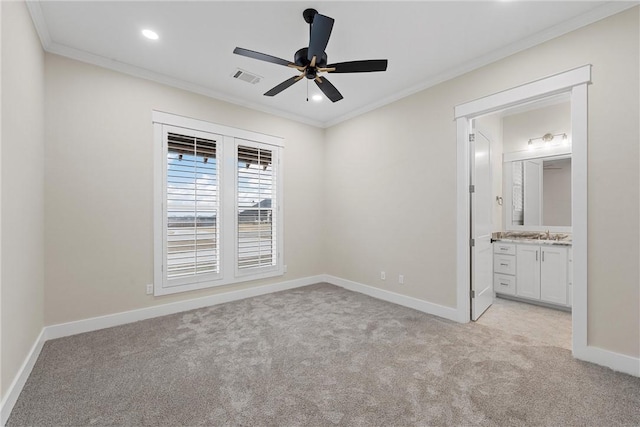 unfurnished bedroom featuring crown molding, ceiling fan, ensuite bathroom, and light carpet