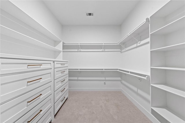 walk in closet featuring light carpet