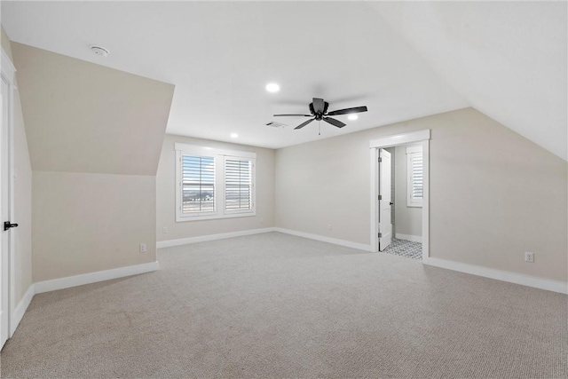 bonus room with vaulted ceiling, light colored carpet, and ceiling fan