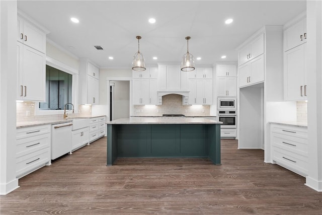 kitchen featuring decorative light fixtures, a kitchen island, white cabinets, and appliances with stainless steel finishes