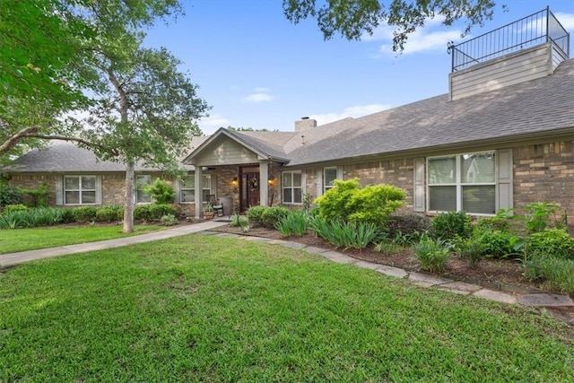 view of front of home with a balcony and a front lawn