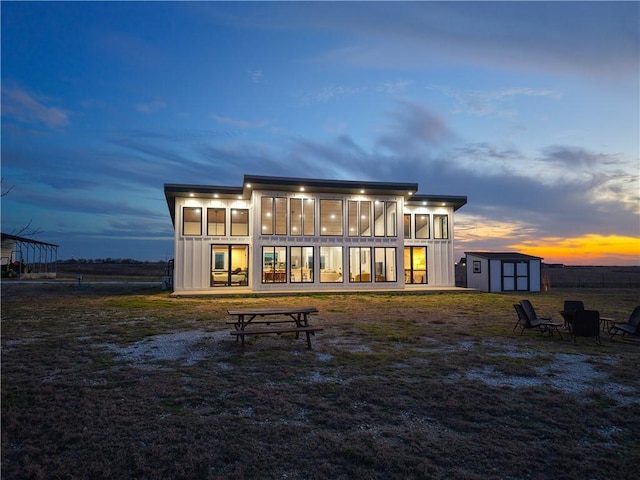 rear view of house featuring an outbuilding, a shed, and a sunroom