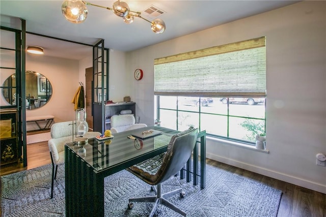 office space with visible vents, baseboards, and wood finished floors